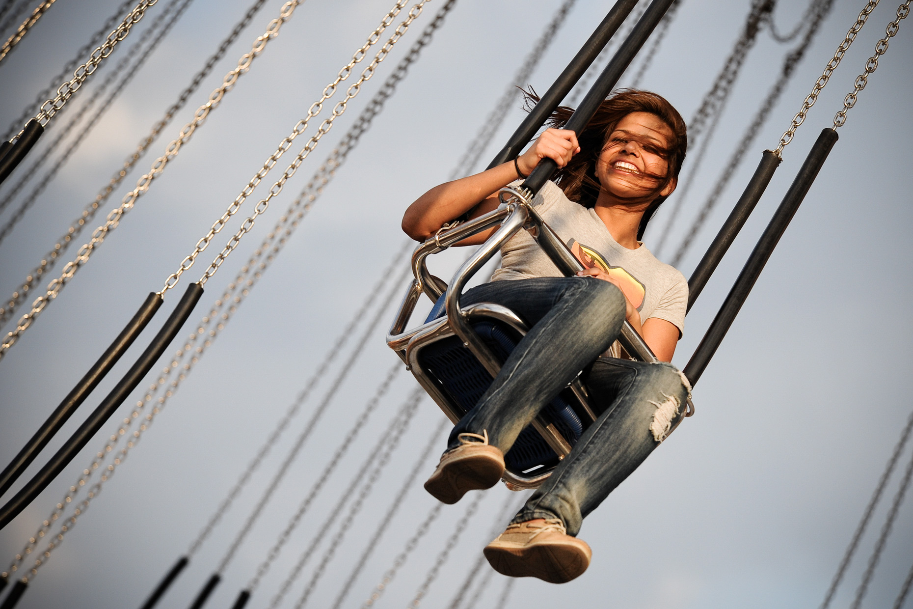 Girl on swings at The State Fair of Texas. Photography by Kevin Brown